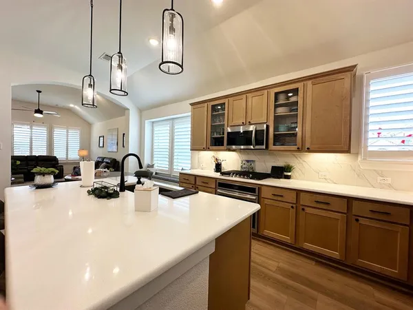 a kitchen with stainless steel appliances a sink stove and cabinets