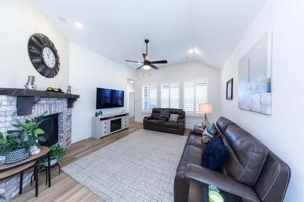 a living room with furniture a flat screen tv and a fireplace