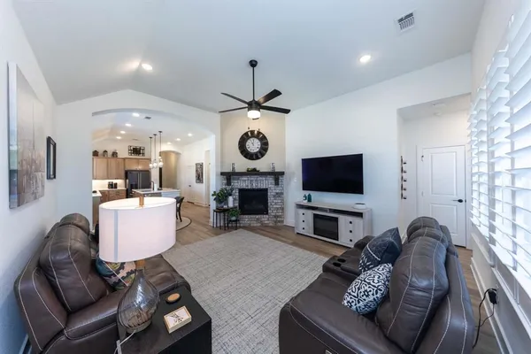 a living room with furniture a flat screen tv and a fireplace