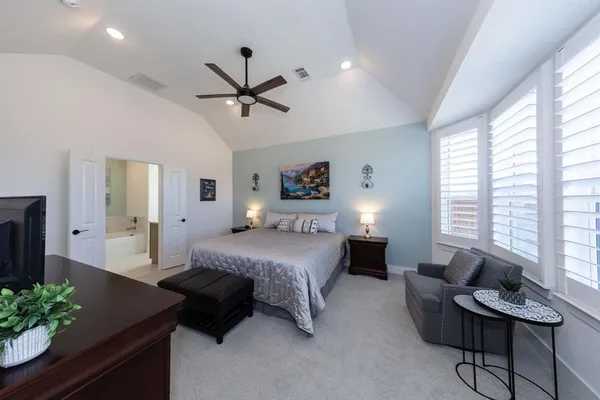 a spacious bedroom with a bed window and a couch