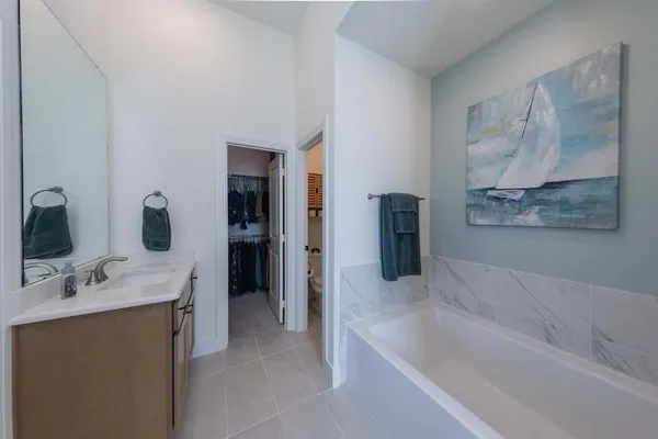 a bathroom with a tub sink and mirror