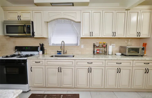 a kitchen with white cabinets and black appliances