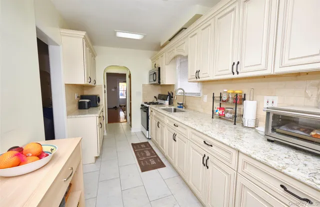 a kitchen with granite countertop stainless steel appliances sink microwave and cabinets