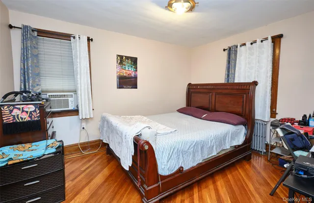 a bedroom with a bed and a flat tv screen on the dresser
