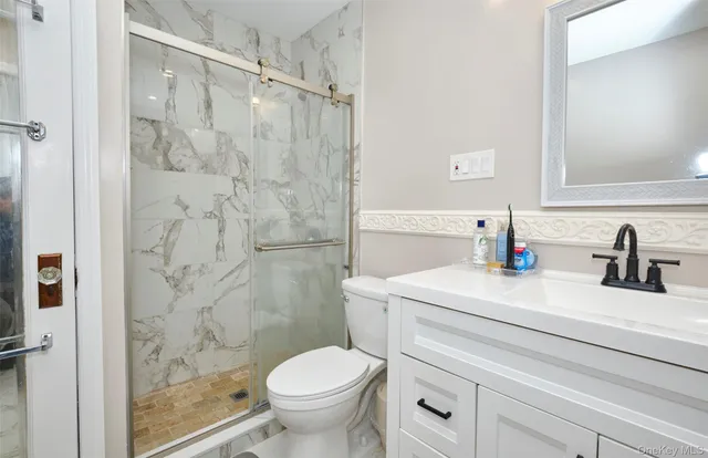 a bathroom with a sink toilet vanity and shower