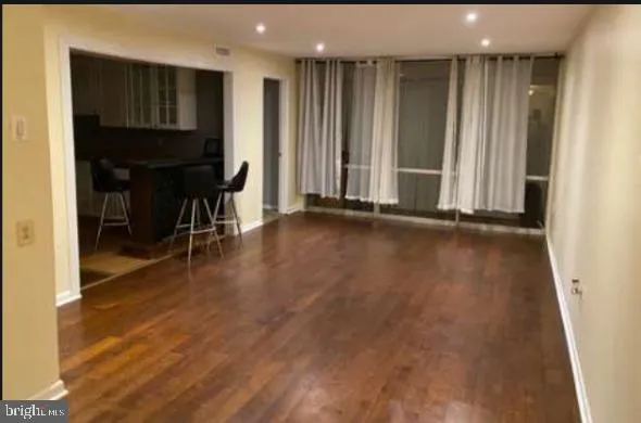 an empty room with wooden floor and furniture