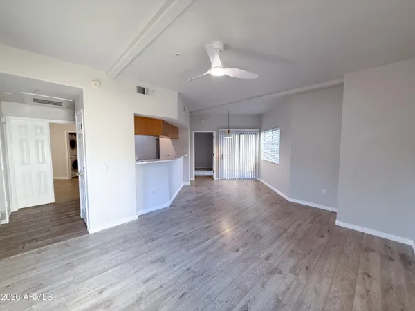 a view of a big room with wooden floor and windows