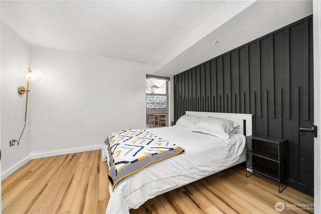 a bedroom with a bed and wooden floor