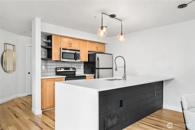 a kitchen with a sink stainless steel appliances and white cabinets