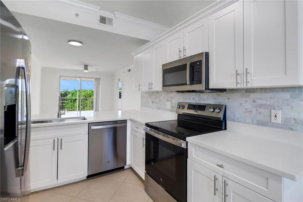 8451 Kingbird Loop, Unit 334 Estero, FL 33967 - Photo 1 of 26 a kitchen with white cabinets appliances a sink and a window