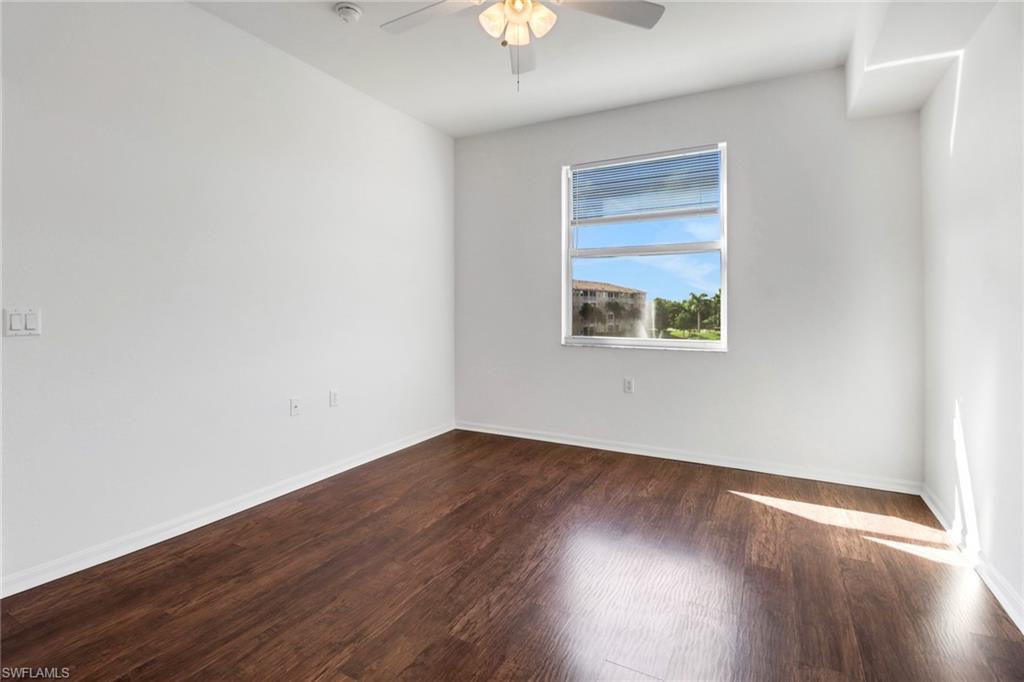 8451 Kingbird Loop, Unit 334 Estero, FL 33967 - Photo 12 of 26 an empty room with wooden floor and windows
