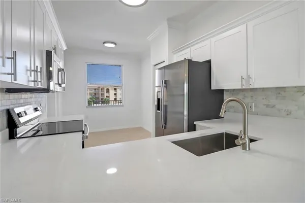 a kitchen with stainless steel appliances a refrigerator sink and cabinets