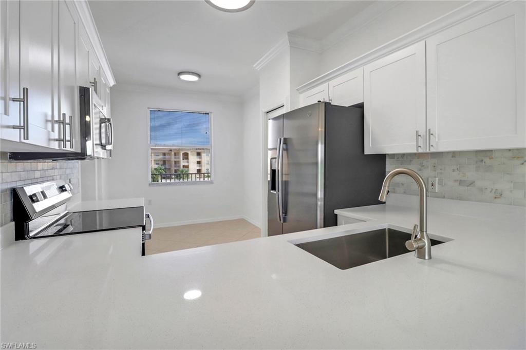 8451 Kingbird Loop, Unit 334 Estero, FL 33967 - Photo 2 of 26 a kitchen with stainless steel appliances a refrigerator sink and cabinets