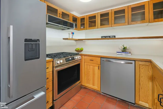 a kitchen with stainless steel appliances granite countertop a stove a sink and a refrigerator