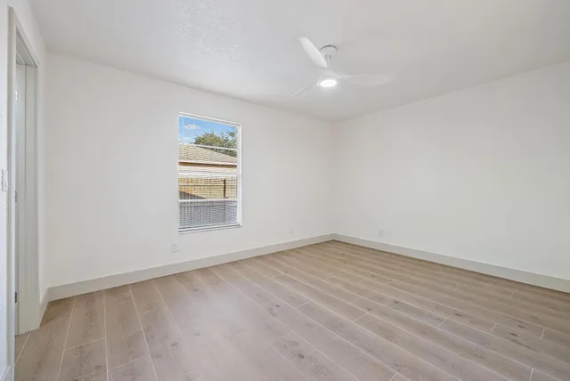 wooden floor in an empty room with a window