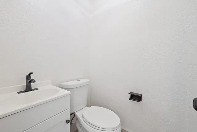 a bathroom with a toilet a sink and mirror