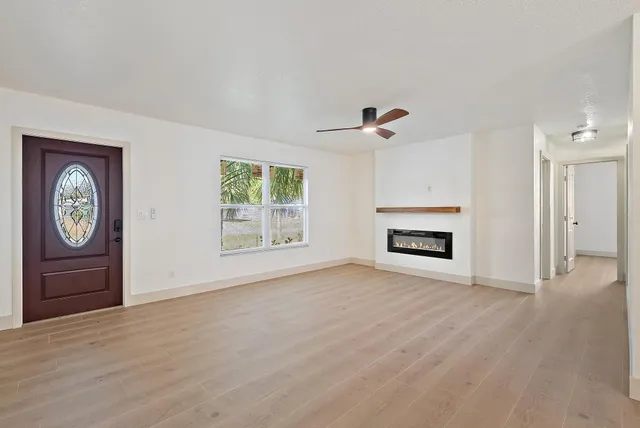 a view of an empty room with a fireplace and a window