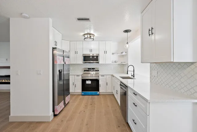 a kitchen with stainless steel appliances a refrigerator sink and cabinets