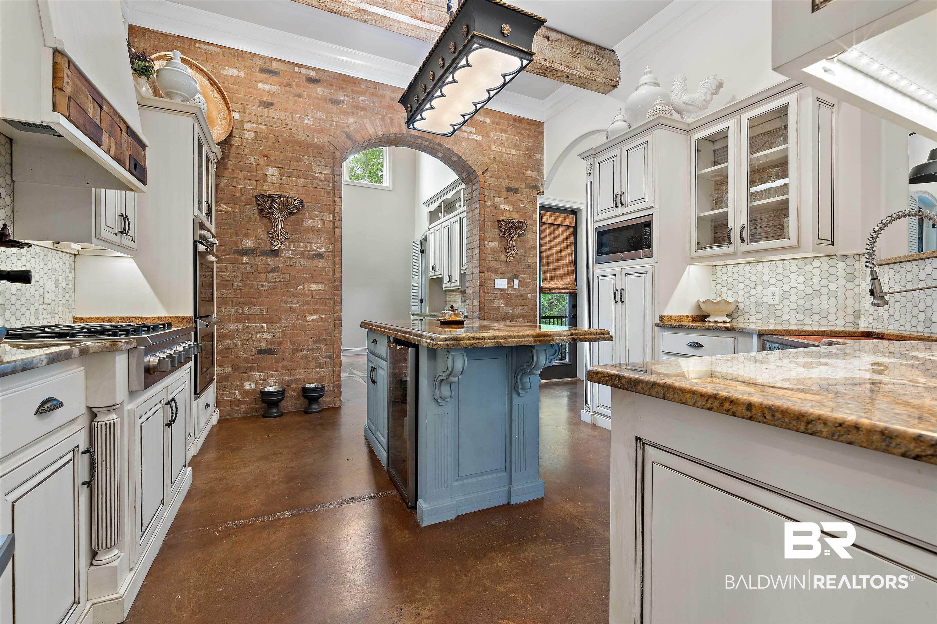 3584 Rue Royal Mobile, AL 36693 - Photo 11 of 35 Kitchen featuring brick wall, a sink, glass insert cabinets, concrete flooring, and appliances with stainless steel finishes