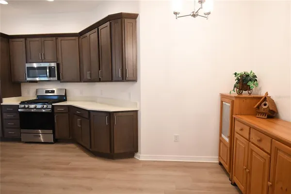 a kitchen with stainless steel appliances granite countertop a stove a microwave and a refrigerator