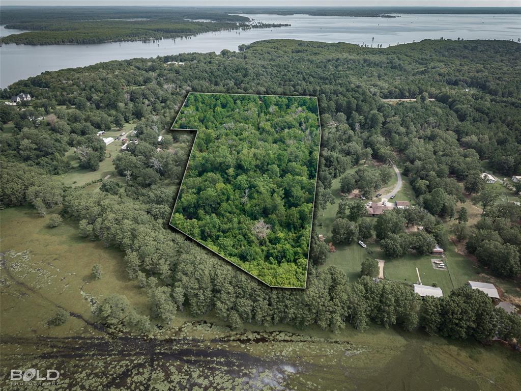 11015 Hereford Road Mooringsport, LA 71060 - Photo 3 of 18 Expansive wooded parcel outlined in black, offering a natural landscape with dense tree coverage