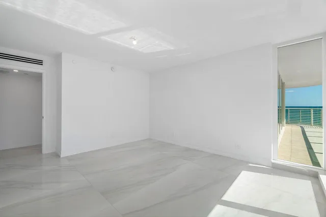 an empty room with wooden floor and a tub