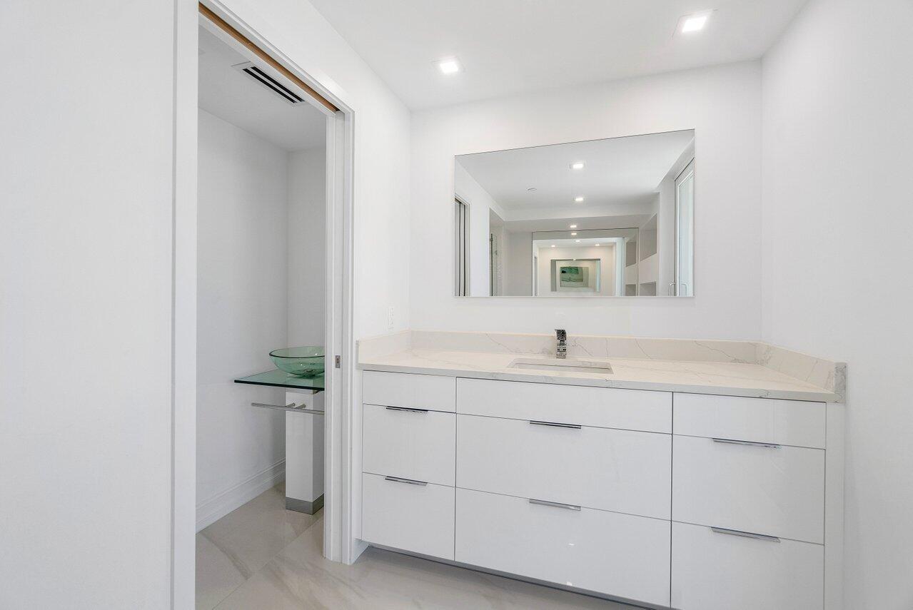 3505 South Ocean Boulevard, Unit 4S Highland Beach, FL 33487 - Photo 36 of 48 a bathroom with a sink a vanity and mirror