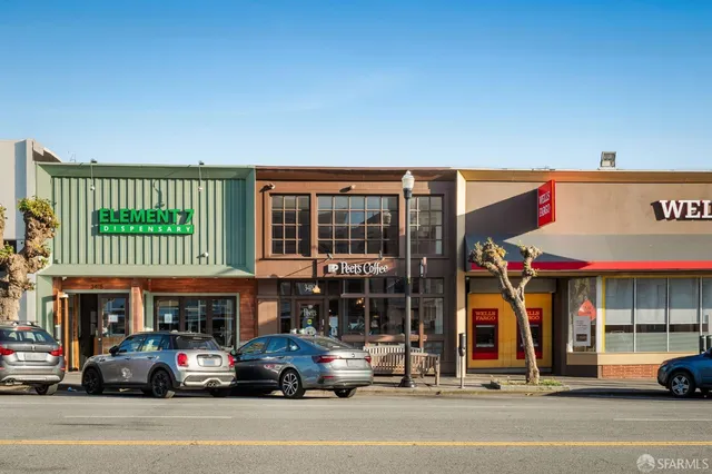 a front view of a house with garden and trees