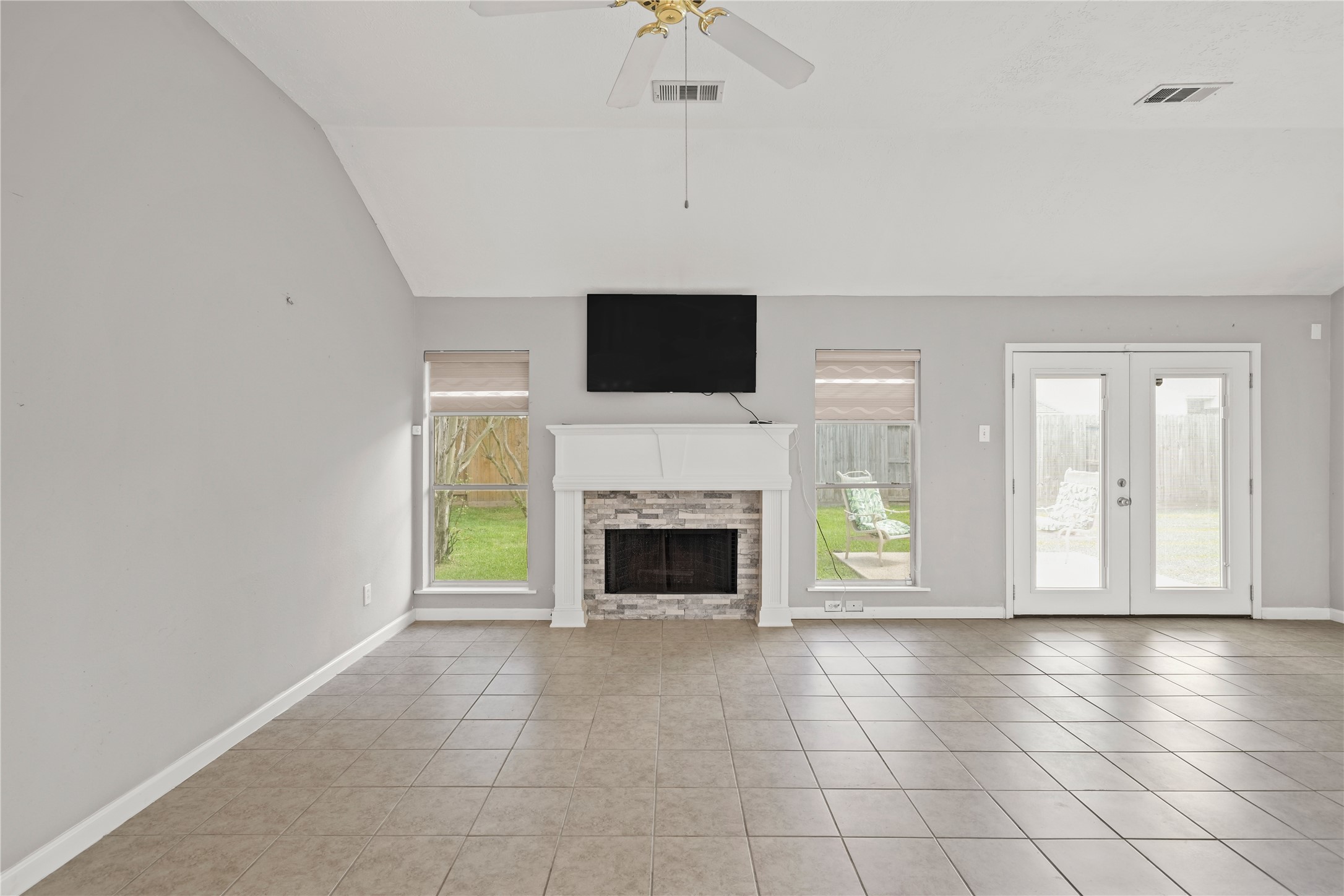 8134 Blue Jay Street Baytown, TX 77523 - Photo 8 of 31 The generously sized living area showcases a gas fireplace, soaring vaulted ceilings, and a timeless open-concept design, offering an ideal setting for both everyday living and refined entertaining.