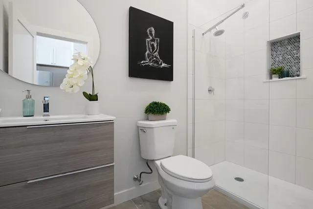 a bathroom with a toilet a sink and mirror