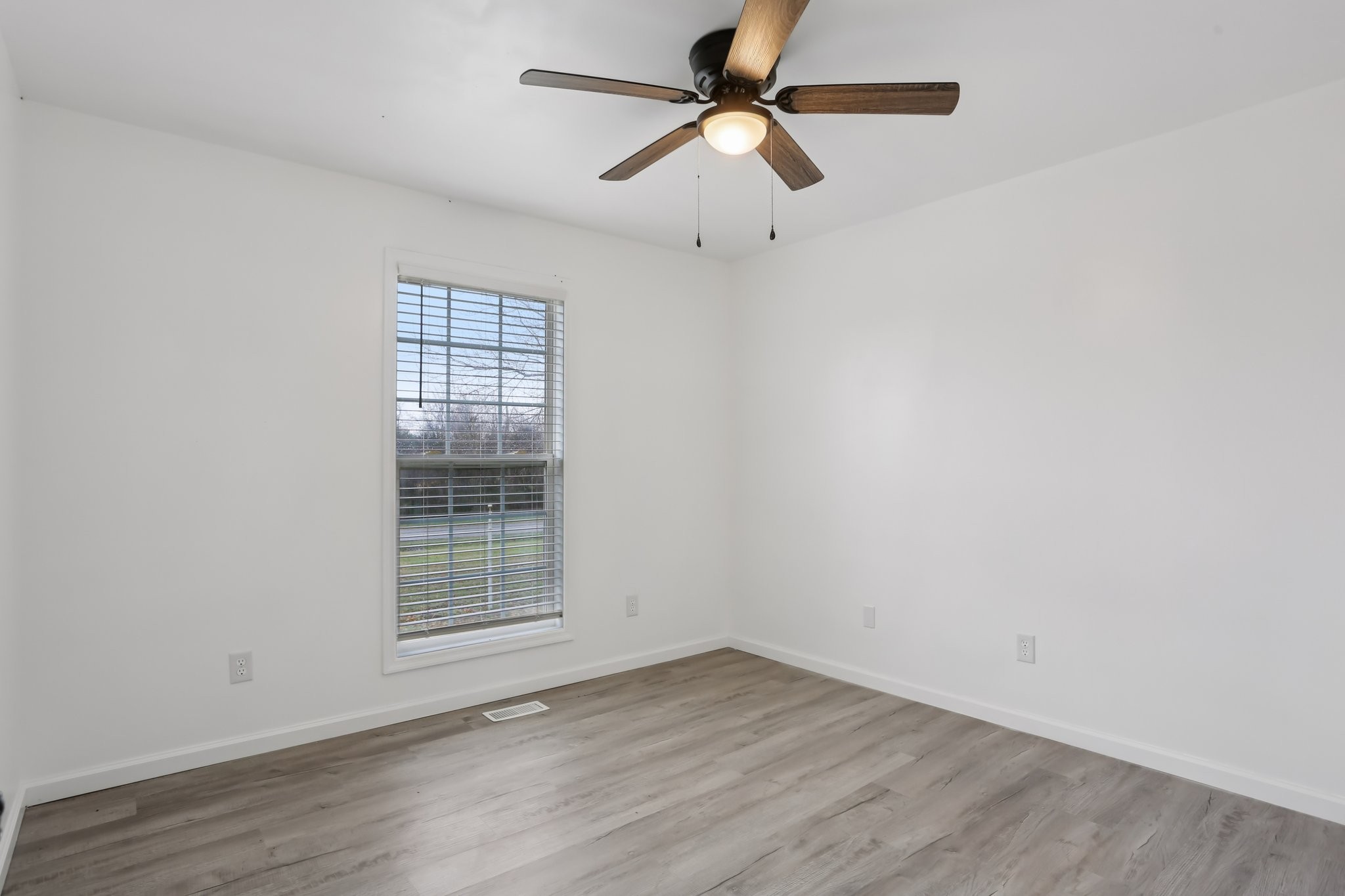 1101 Bugscuffle Road Wartrace, TN 37183 - Photo 25 of 42 an empty room with wooden floor ceiling fan and windows