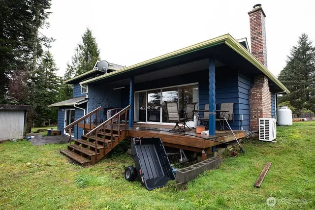 a view of a house with a backyard and wooden deck