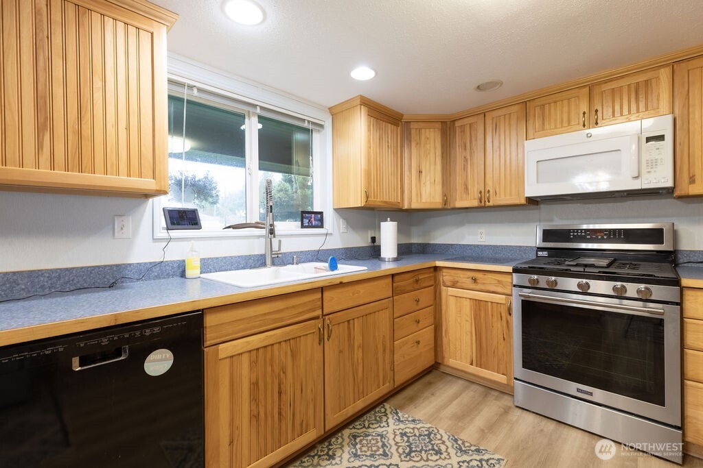 194 Sekiu Airport Road Sekiu, WA 98381 - Photo 4 of 40 a kitchen with stainless steel appliances granite countertop a sink stove and cabinets