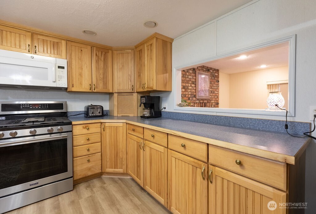 194 Sekiu Airport Road Sekiu, WA 98381 - Photo 5 of 40 a kitchen with granite countertop white cabinets stainless steel appliances and sink