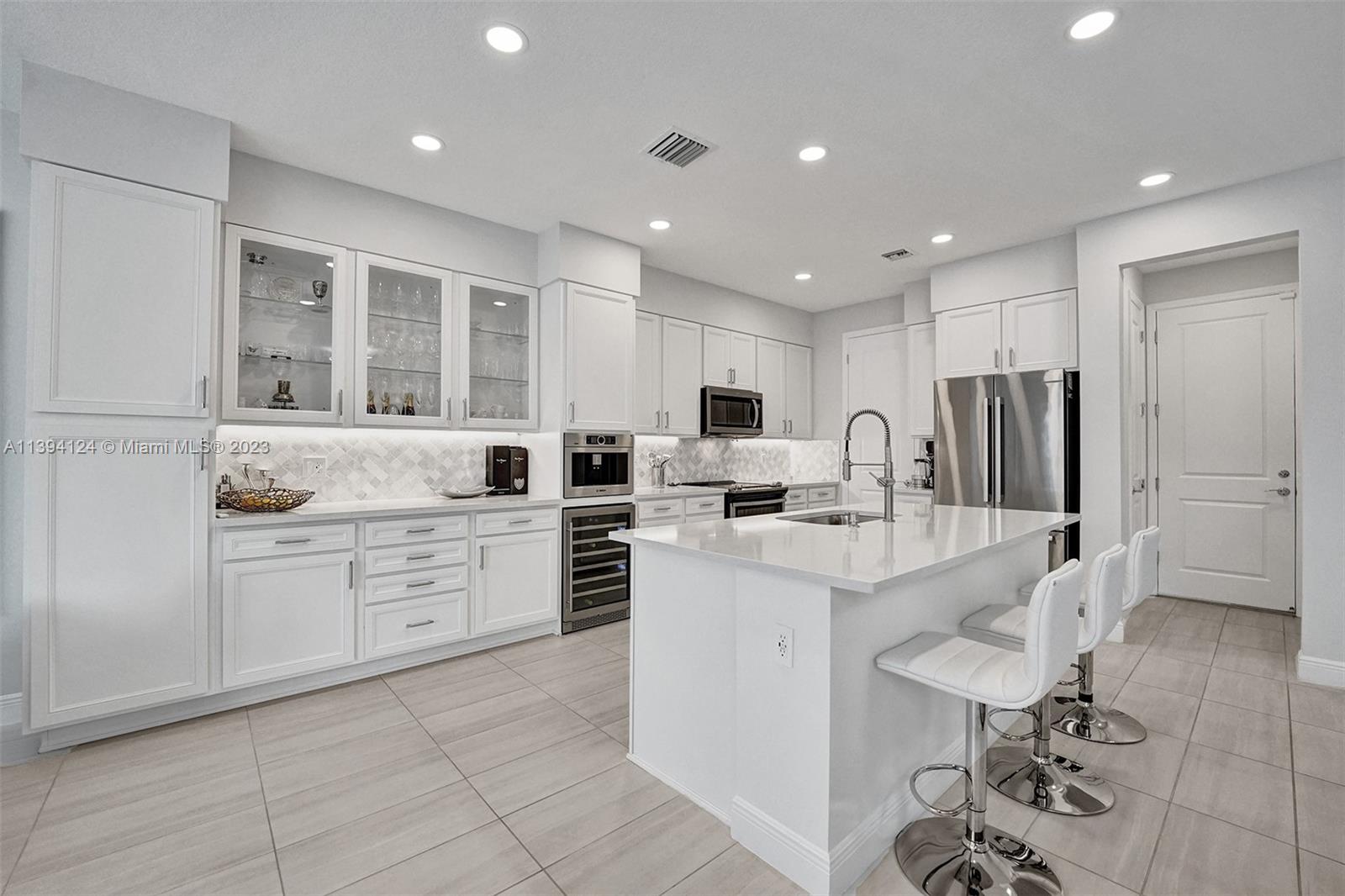 a kitchen with white cabinets and stainless steel appliances