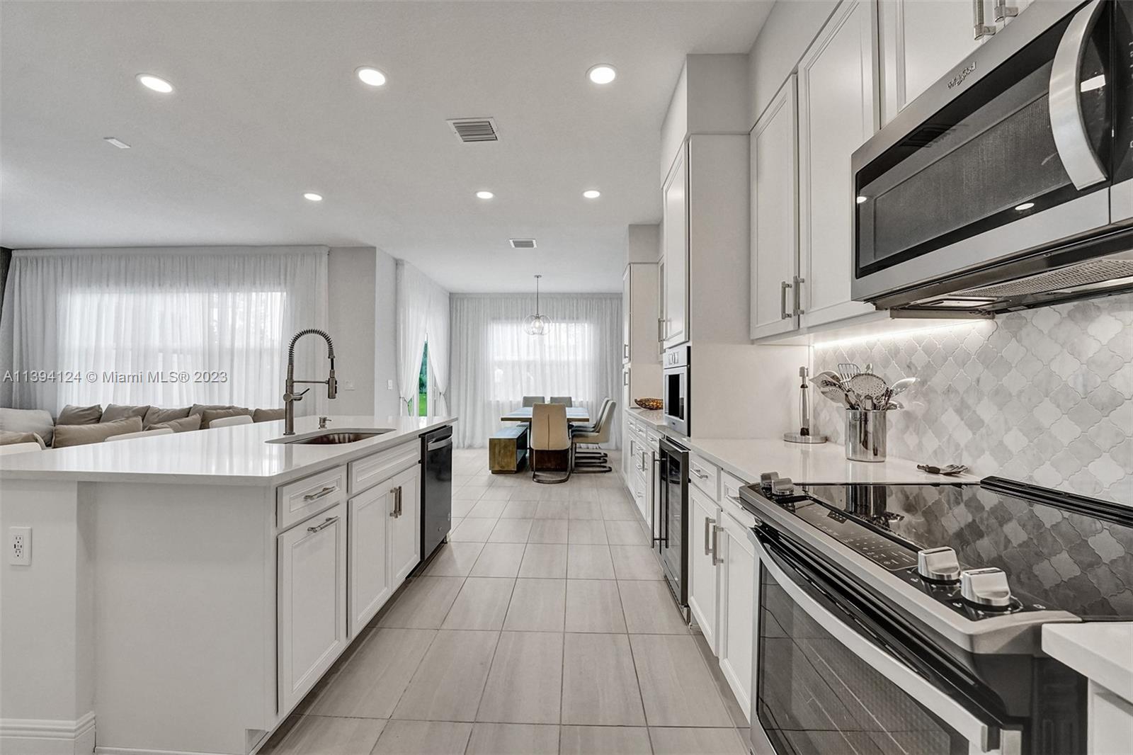 1033 Eucalyptus Drive Hollywood, FL 33021 - Photo 12 of 66 a large kitchen with stainless steel appliances granite countertop a sink and stove top oven