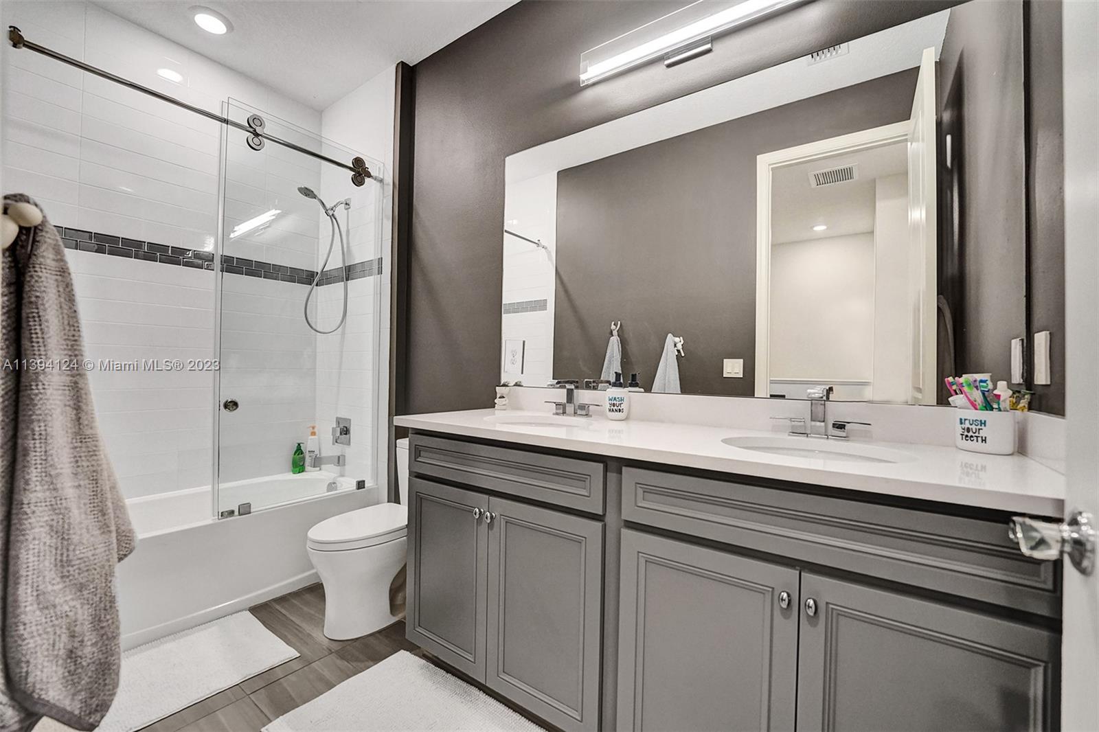 1033 Eucalyptus Drive Hollywood, FL 33021 - Photo 27 of 66 a bathroom with a double vanity sink toilet mirror and shower