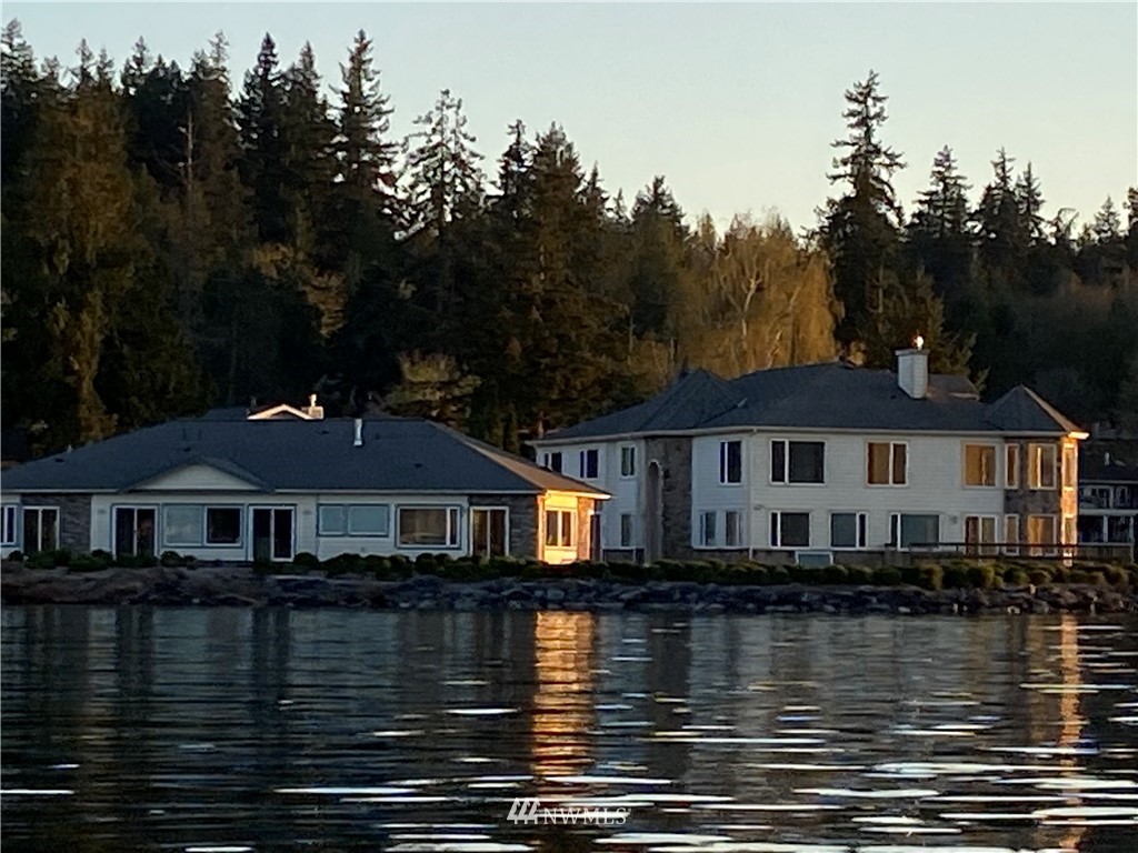 a front view of a house with yard and lake view