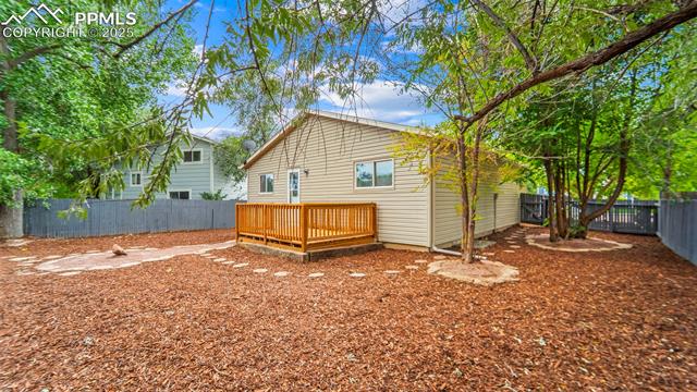 562 Blossom Field Road Fountain, CO 80817 - Photo 35 of 41 Back of house with a fenced backyard and a wooden deck
