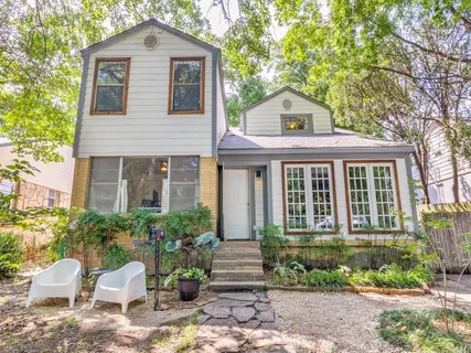 a front view of a house with a yard and potted plants