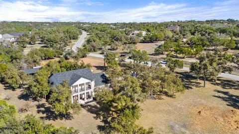 an aerial view of residential houses with outdoor space and trees