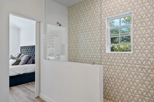 a bedroom with a bed and a window with chair