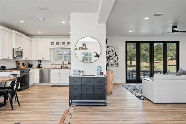 a large kitchen with kitchen island a large counter space a sink stainless steel appliances and cabinets