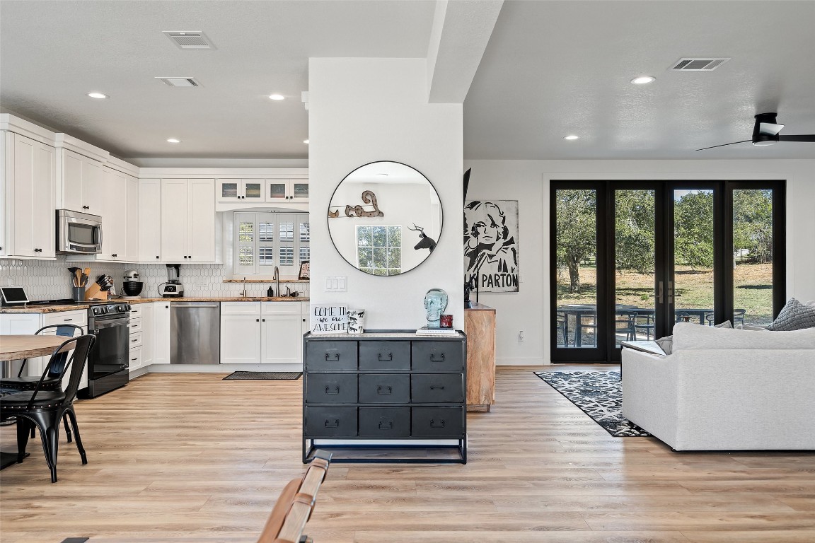 310 Saddle Blanket Drive Dripping Springs, TX 78620 - Photo 3 of 40 a large kitchen with kitchen island a large counter space a sink stainless steel appliances and cabinets