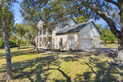 a view of a house with backyard and a tree