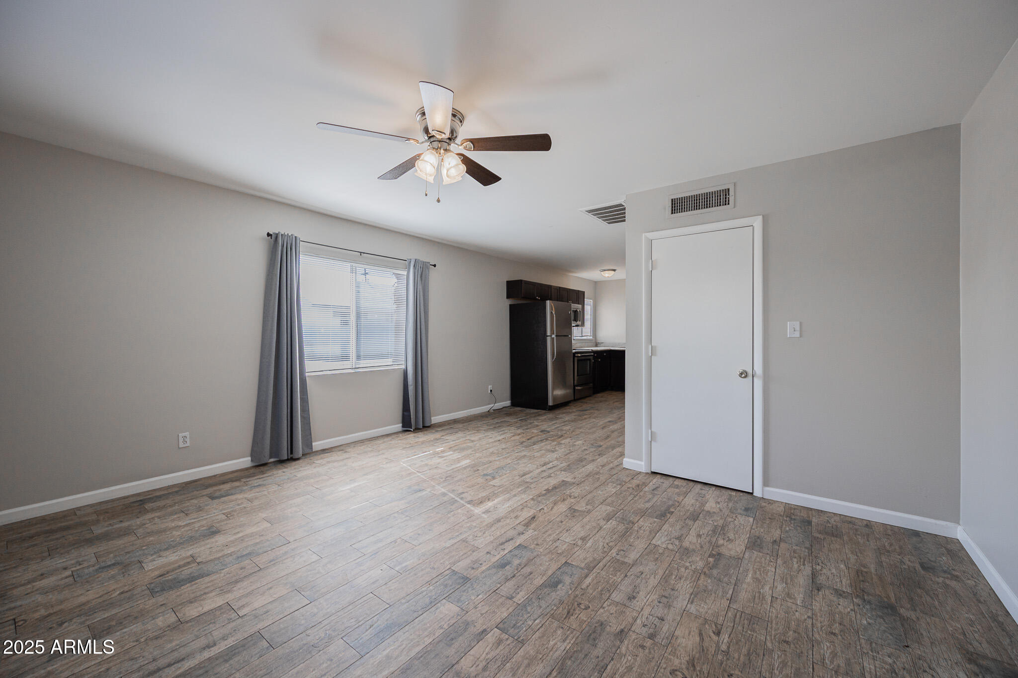 1507 East Harvard Street, Unit A Phoenix, AZ 85006 - Photo 3 of 14 a view of empty room with wooden floor and ceiling fan