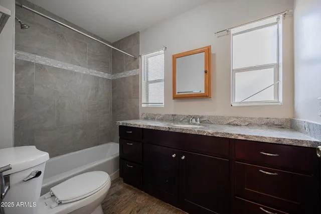 a bathroom with a granite countertop sink toilet and shower