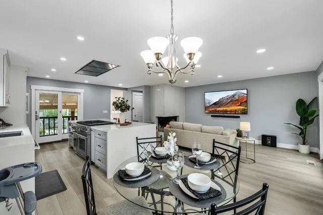 a view of a dining room with furniture a chandelier and wooden floor