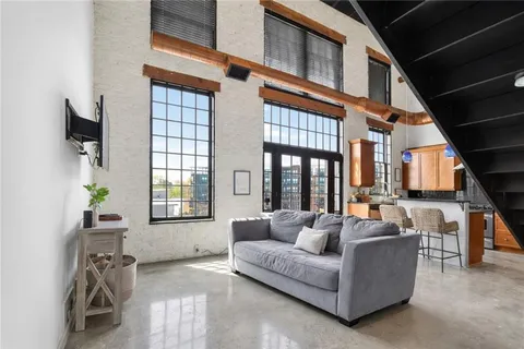 a living room with furniture a flat screen tv and windows
