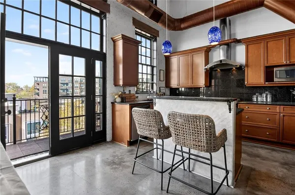 a kitchen with stainless steel appliances granite countertop a sink and a refrigerator
